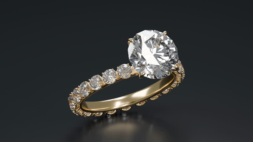 A gold diamond ring lit against a dark background